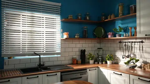 Pencere önünde beyaz metro fayanslı tezgâh, eviye ve raflar